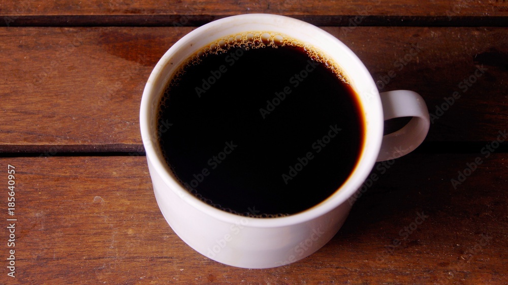 Coffee in white cup on wooden board