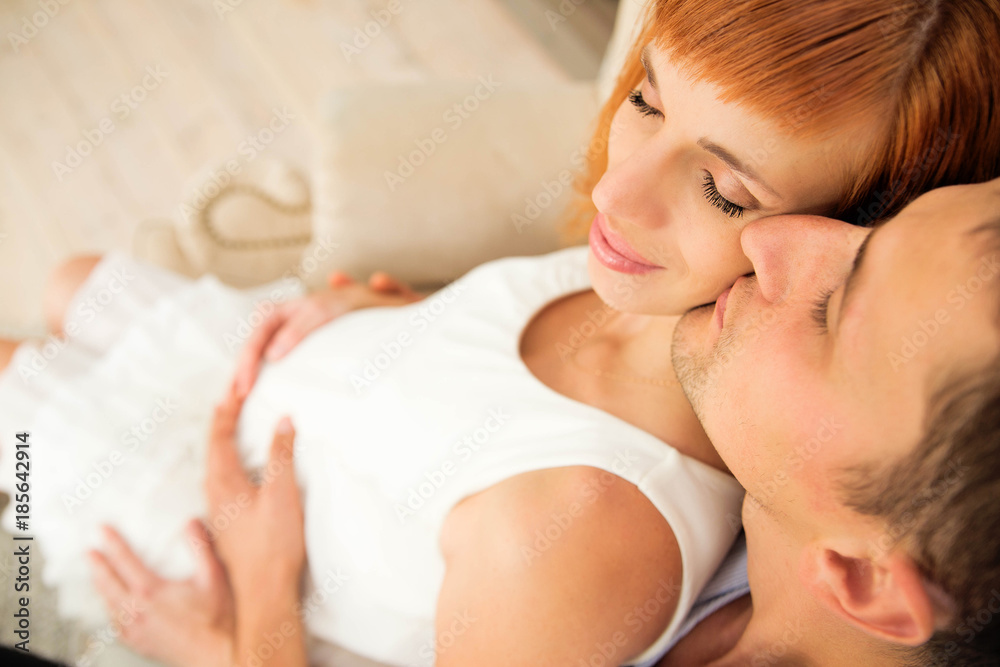 loving husband kisses his pregnant wife. Top view loving husband kisses his pregnant wife. Top view