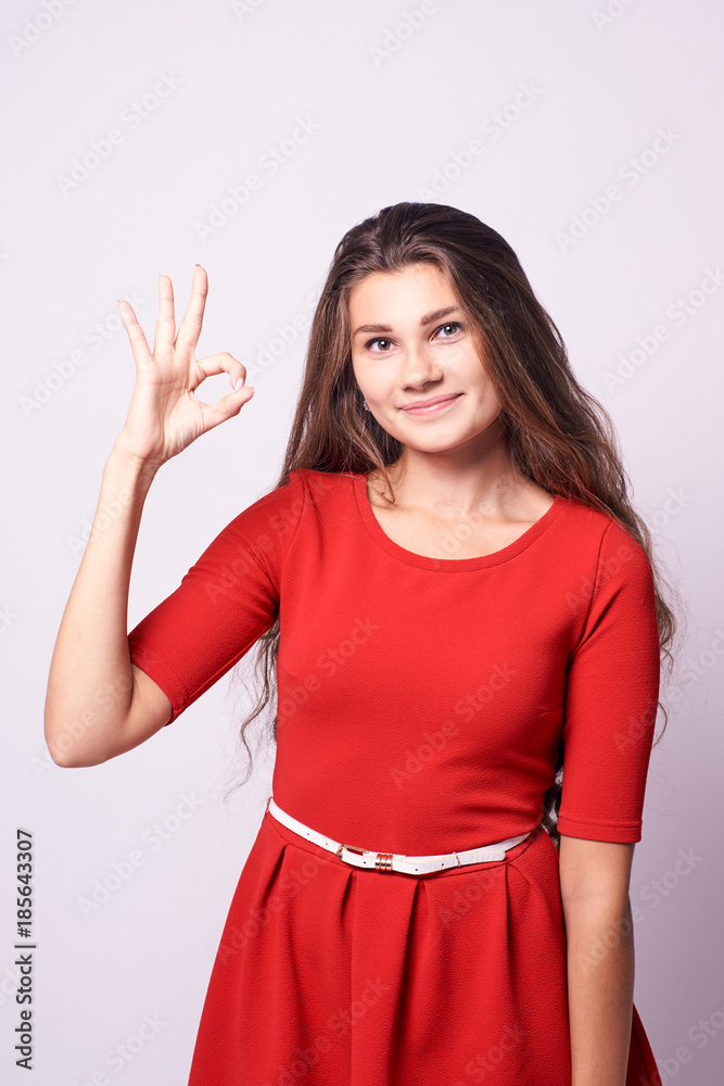 Beautiful girl. Gesture consent. Portrait brunette. White background Beautiful girl. Gesture consent. Portrait brunette. White background