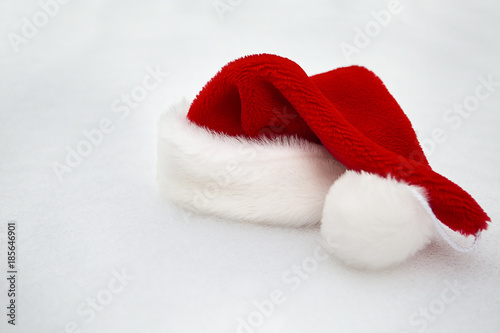 Kerstmuts in de sneeuw. Santa hat in the snow. Red Santa hat, Christmas, holidays, snow, winter, December.