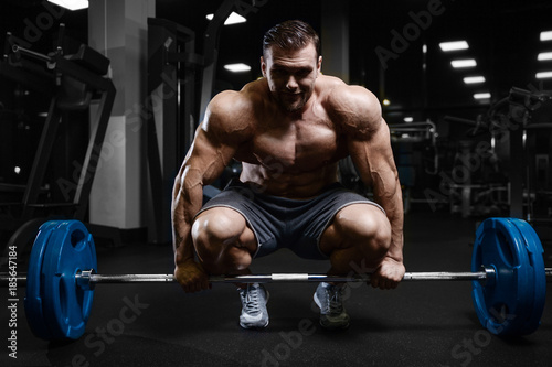 Brutal strong bodybuilder athletic men pumping up muscles with dumbbells.