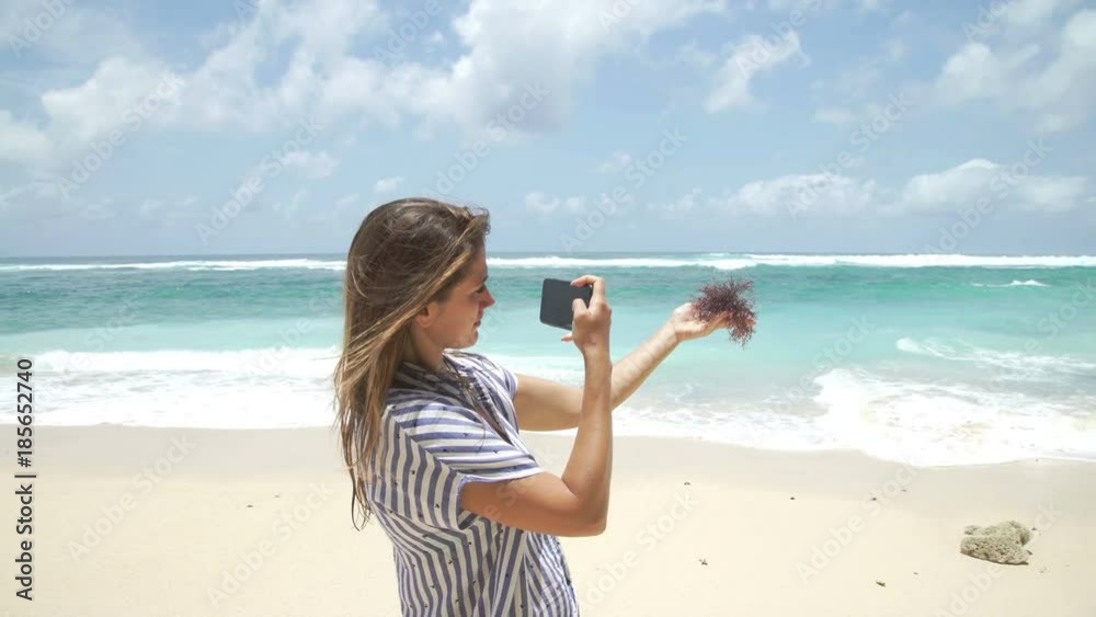Beautiful woman taking photo using phone on beach Bali Indonesia Beautiful woman taking photo using phone on beach Bali Indonesia