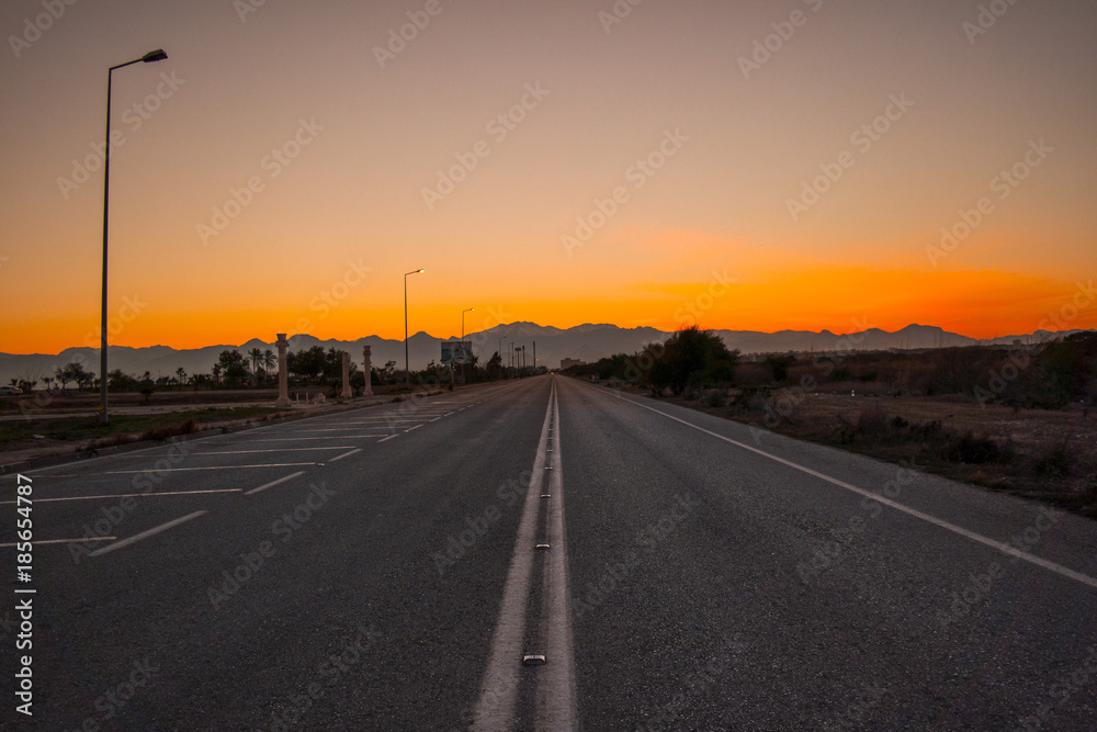 Fototapeta premium On a lonely road in sunset all alone