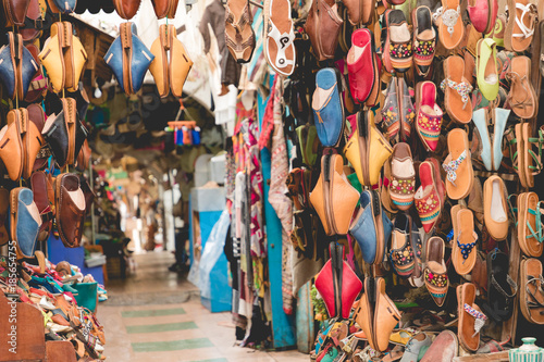 Moroccan leather goods bags and slippers at outdoor market in Marrakesh, Morocco.