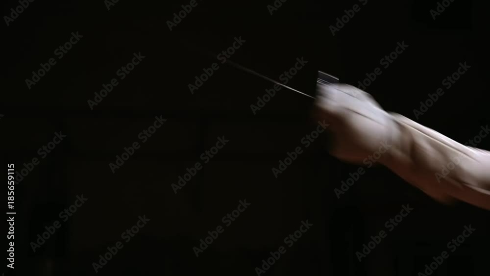 Closeup of a rapier for fencing in the hand performs offensive movements Closeup of a rapier for fencing in the hand performs offensive movements