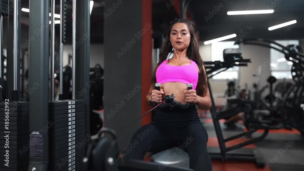 Beautiful woman at the sports club does different kind of exercises on the simulators for being in good shape, fitness and beauty, cardio and strength exercises, sporting club Beautiful woman at the sports club does different kind of exercises on the simulators for being in good shape, fitness and beauty, cardio and strength exercises, sporting club