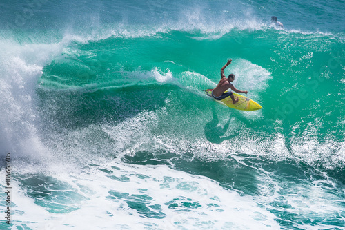 Surfer riding big green wave at Padang Padang beach, Bali, Indonesia photo