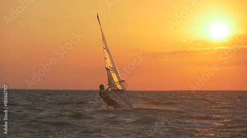 Shining water droplets on a windsurf sail in the sunset