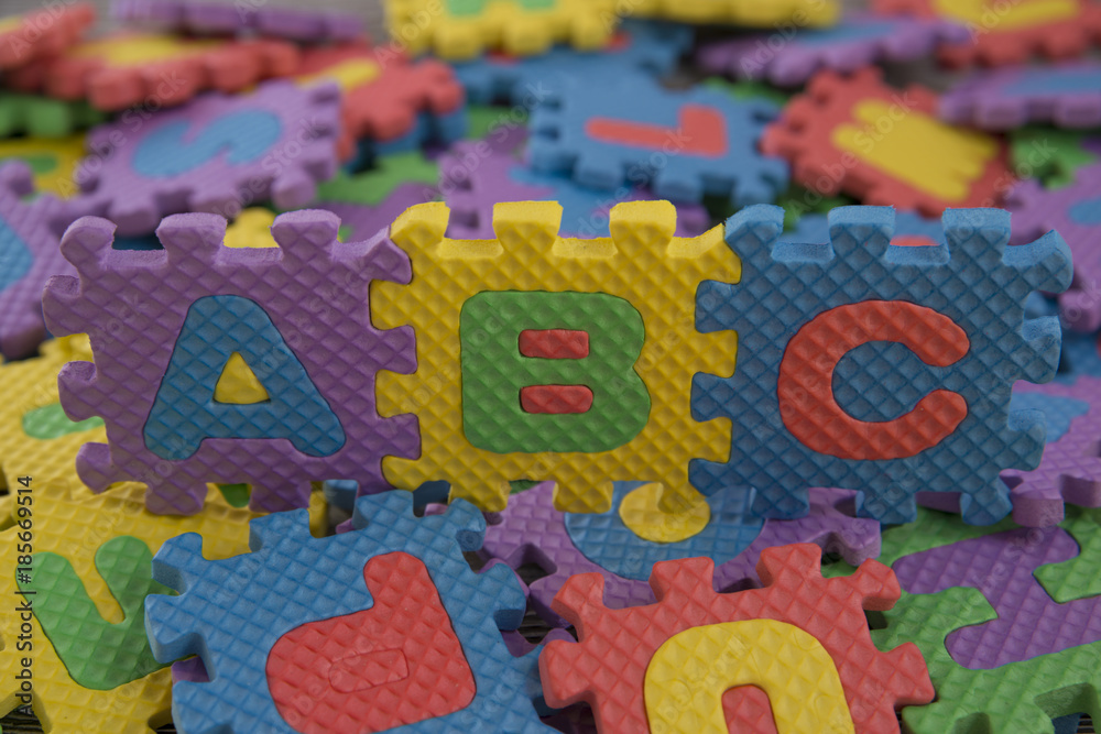 the alphabet children's puzzles. abc against the background of scattered colored pieces of the puzzle the alphabet children's puzzles. abc against the background of scattered colored pieces of the puzzle