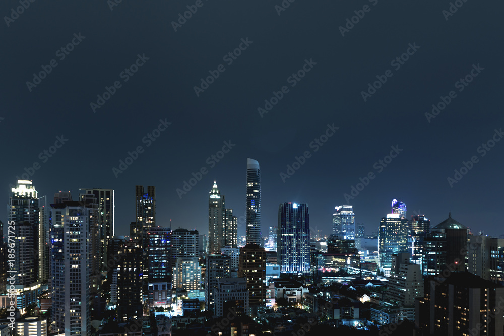 City scape over night sky. Groups of tall commercial building on night sky in background.