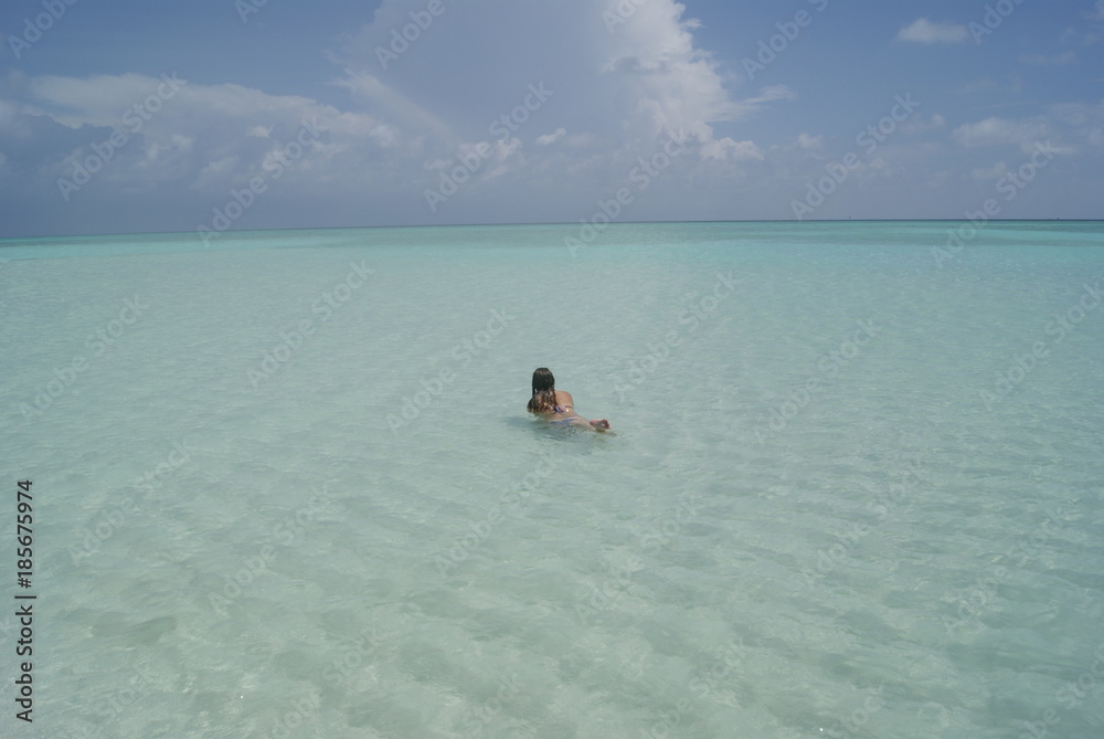 Girl swimming in a amazing beach of Maldives islands