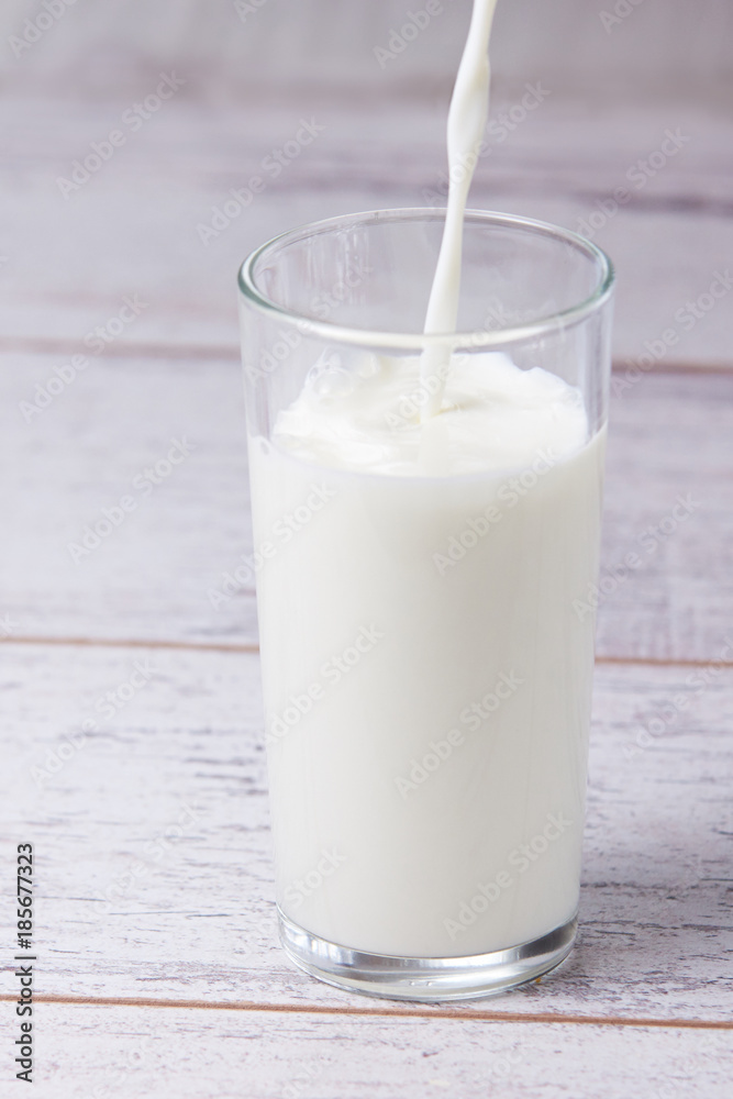 White drink. Fill glass milk. Light background