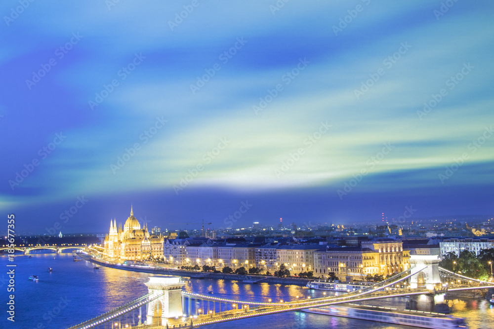 Beautiful view of the Hungarian Parliament and the Szechenyi chain bridge across the Danube in the panorama of Budapest at night, Hungary