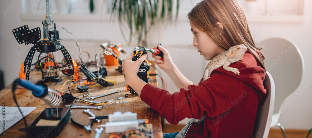 Fotografie Girl building robot