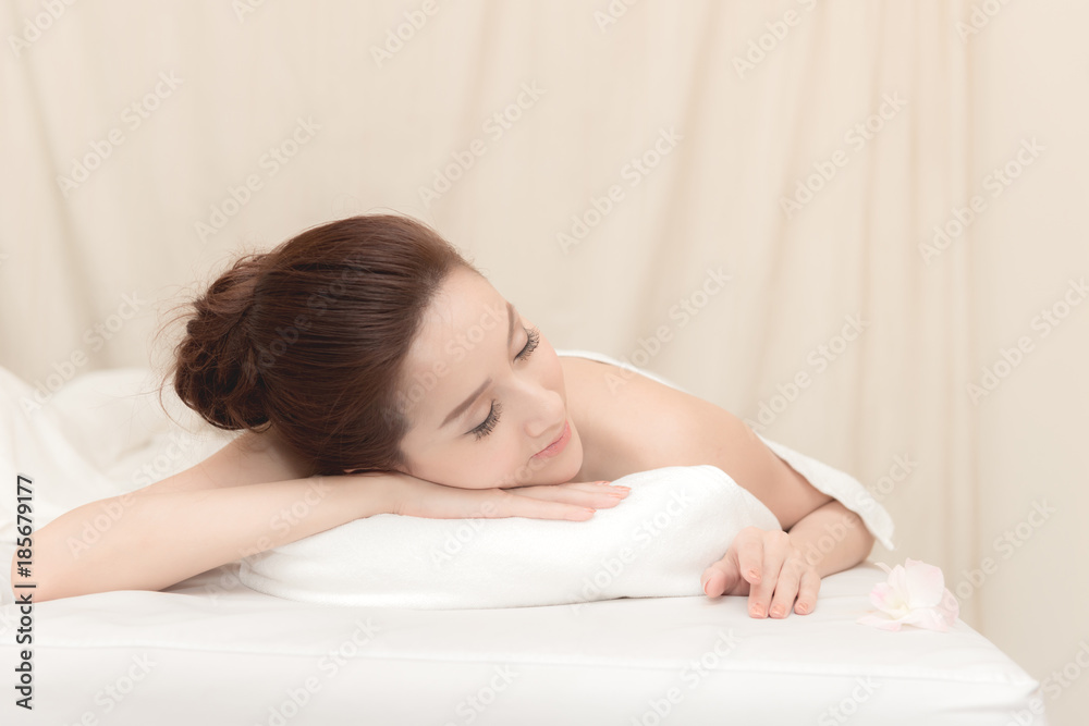 Asian exotic holiday spa concept. Beautiful young chinese woman enjoy relaxing during massage at spa, taken indoor in real spa location. Asian exotic holiday spa concept. Beautiful young chinese woman enjoy relaxing during massage at spa, taken indoor in real spa location.
