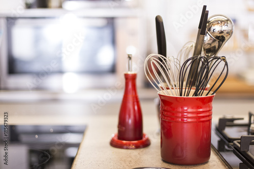 Red cooking utensils on a pot on an industrial kitchen