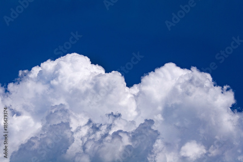 White cumulus clouds against a bright blue sky (background)