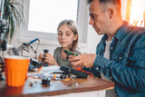 Father and daughter working on electronics components