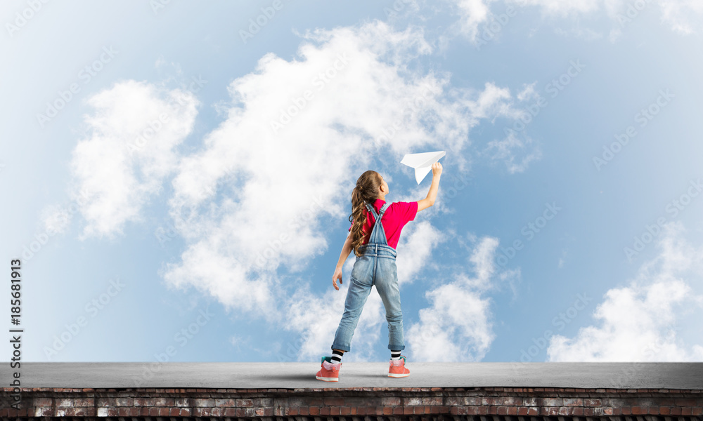 Concept of careless happy childhood with girl dreaming to become pilot Concept of careless happy childhood with girl dreaming to become pilot