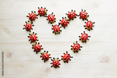 Canvas Print heart formed with chocolate ladybugs on bright wood
