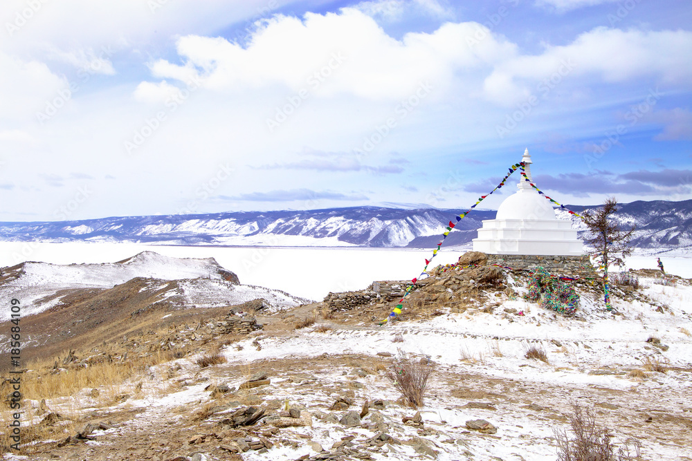 Buddhist stupa of enlightenment on the island Ogoy with flags. Baikal.
