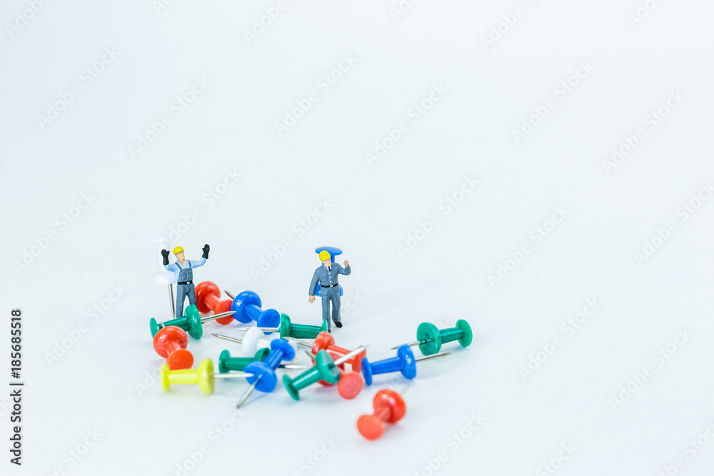 Selective focus of Miniature Worker People, Working with push pin , on white background