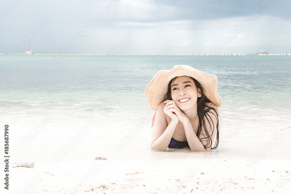 Beautiful young single chinese woman having fun on beach. laying down happy relaxing, wearing bikini, beach hat. Beautiful young single chinese woman having fun on beach. laying down happy relaxing, wearing bikini, beach hat.