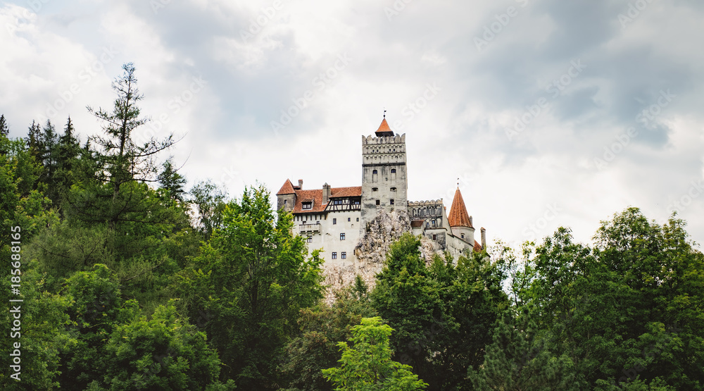 Bran or Dracula Castle in Transylvania, Romania. The castle is located on top of a mountain under a gloomy cloudy sky