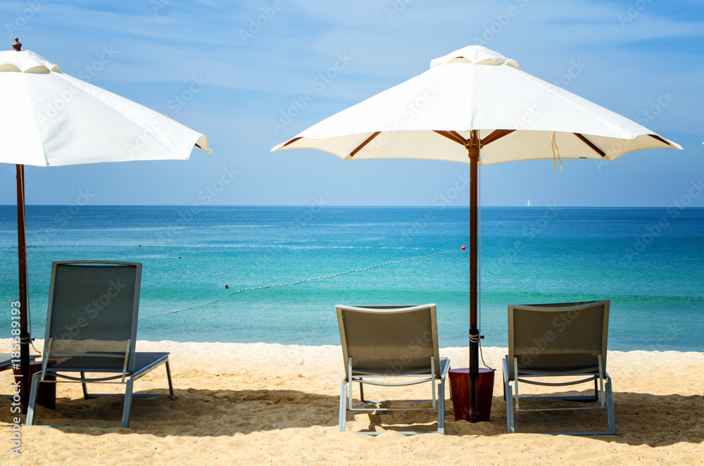 White umbrella and deckchair on the beach White umbrella and deckchair on the beach