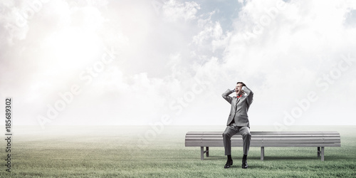 Young man in suit in park dont want to hear anything