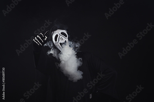 man in a terrible mask and black cloak vape