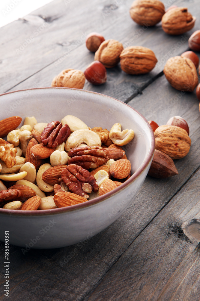 bowl with mixed nuts on wooden background. Healthy food and snack. Walnut, pecan, almonds, hazelnuts and cashews. bowl with mixed nuts on wooden background. Healthy food and snack. Walnut, pecan, almonds, hazelnuts and cashews.