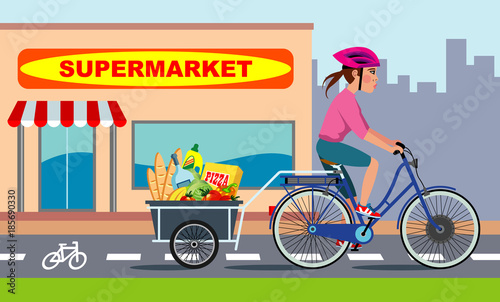 girl riding electric bike with bike trailer full of grocery, runs along a bicycle lane