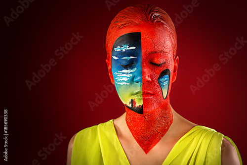 Woman with creative makeup, portrait, face, shoulders. Against the background of the red black studio, sleep, hallucinations, surrealism. Crazy art concept new idea. Part of face landscape, nice view