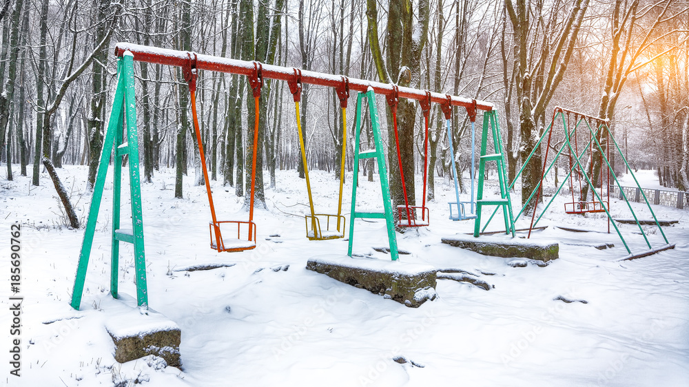 Empty swing in winter time with snow Empty swing in winter time with snow