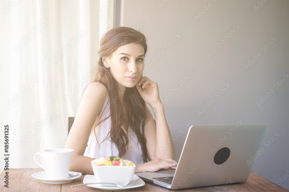 Woman having coffee and working outside. Working on laptop during her vacation in a tropical hotel. White female with white dress. Agile. modile office concept. Woman having coffee and working outside. Working on laptop during her vacation in a tropical hotel. White female with white dress. Agile. modile office concept.