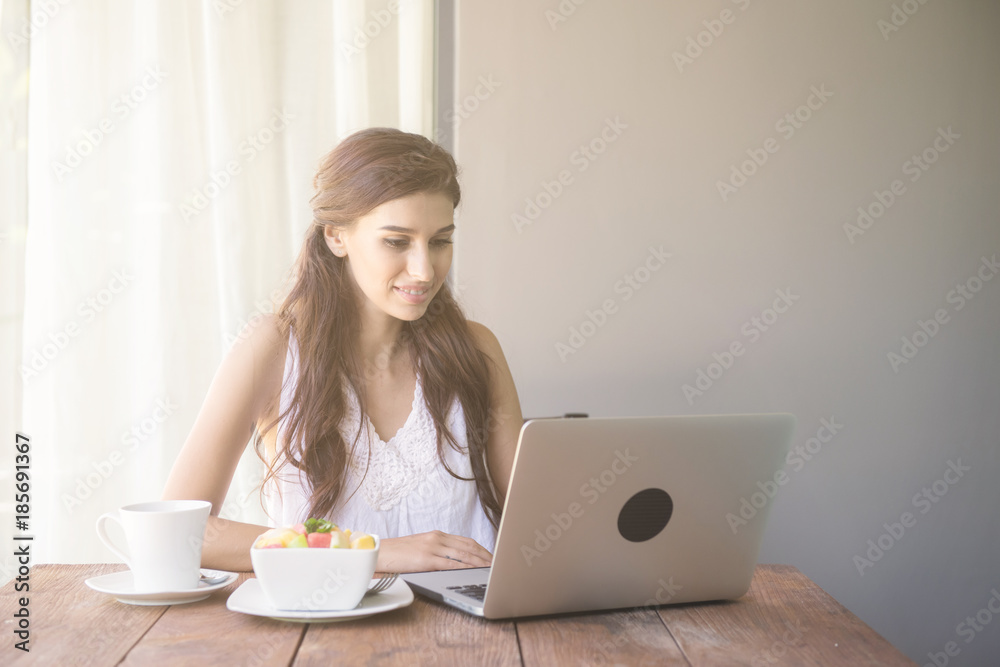 Woman having coffee and working outside. Working on laptop during her vacation in a tropical hotel. White female with white dress. Agile. modile office concept. Woman having coffee and working outside. Working on laptop during her vacation in a tropical hotel. White female with white dress. Agile. modile office concept.