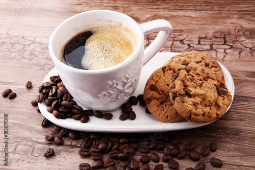Coffee cup with chocolate cookies and coffee beans on wooden background #185691308