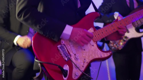 Man playing electric guitar on a stage, musical concert close-up view photo