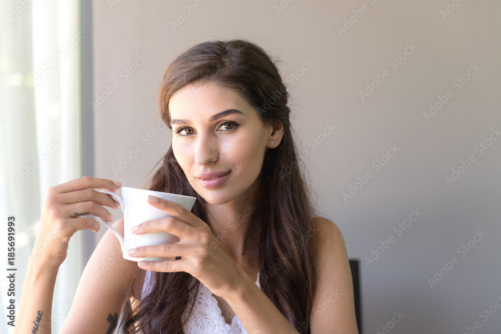 Woman having coffee and smile. Beautiful white woman having her morning coffee and smile looking very happy. Woman having coffee and smile. Beautiful white woman having her morning coffee and smile looking very happy.