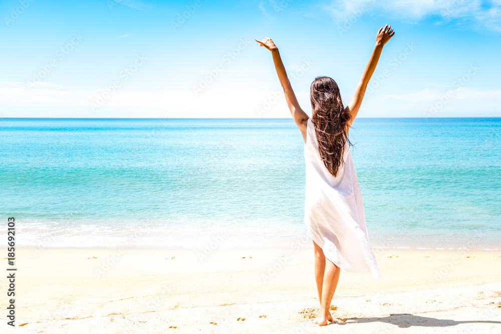 Beautiful young single white woman on beach. Standing happy freedom pose relaxing, wearing white dress. Beautiful young single white woman on beach. Standing happy freedom pose relaxing, wearing white dress.