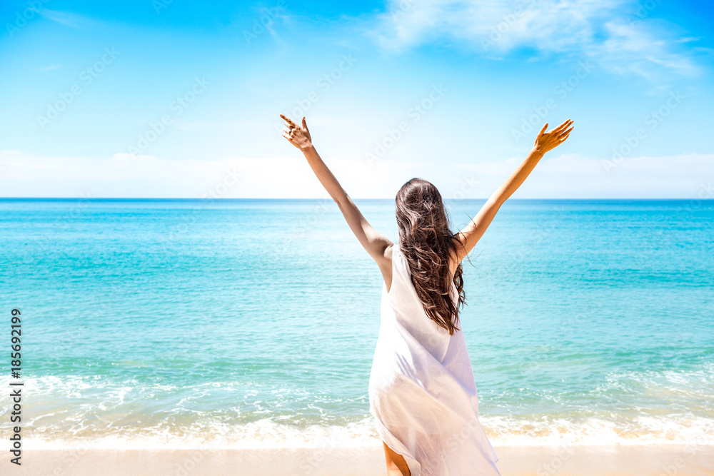 Beautiful young single white woman on beach. Standing happy freedom pose relaxing, wearing white dress. Beautiful young single white woman on beach. Standing happy freedom pose relaxing, wearing white dress.