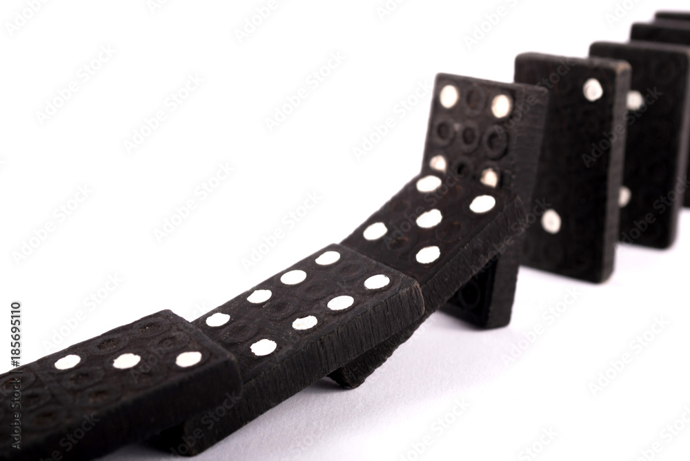 Dominoes falling isolated on white background. Close up. Selective focus. Dominoes falling isolated on white background. Close up. Selective focus.