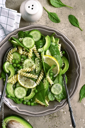 Pasta salad with green vegetables : avocado, baby spinach, green pea and cucumber.Top view.