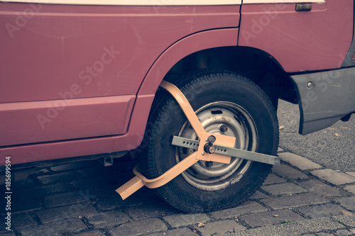 Cepo metálico con candado en rueda de coche.