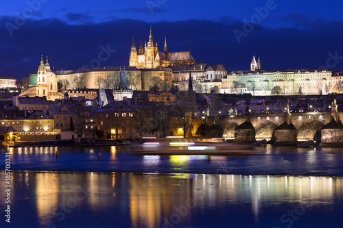 Night colorful snowy Christmas Prague Lesser Town with gothic Castle and Charles Bridge, Czech republic