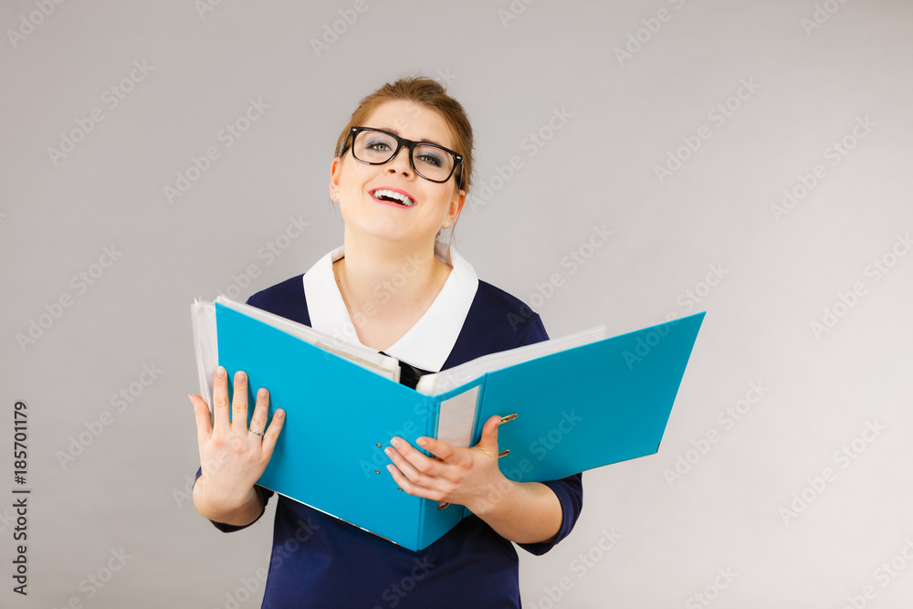 Happy positive business woman holding binder with documents Happy positive business woman holding binder with documents