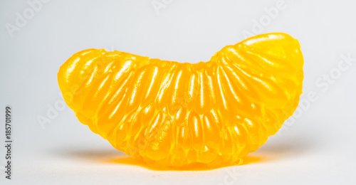 Grains of peeled orange taken by macro photography. A single orange peeled with white background also called pulp orange.