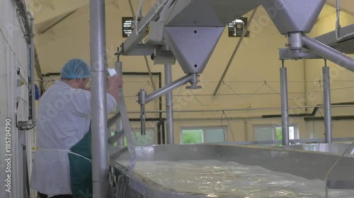 Man changing whisk on cheese making vat for cleaning photo