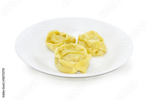 Three boiled manti on the white dish on a white background